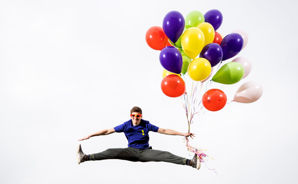 teenager jumping with balloons
