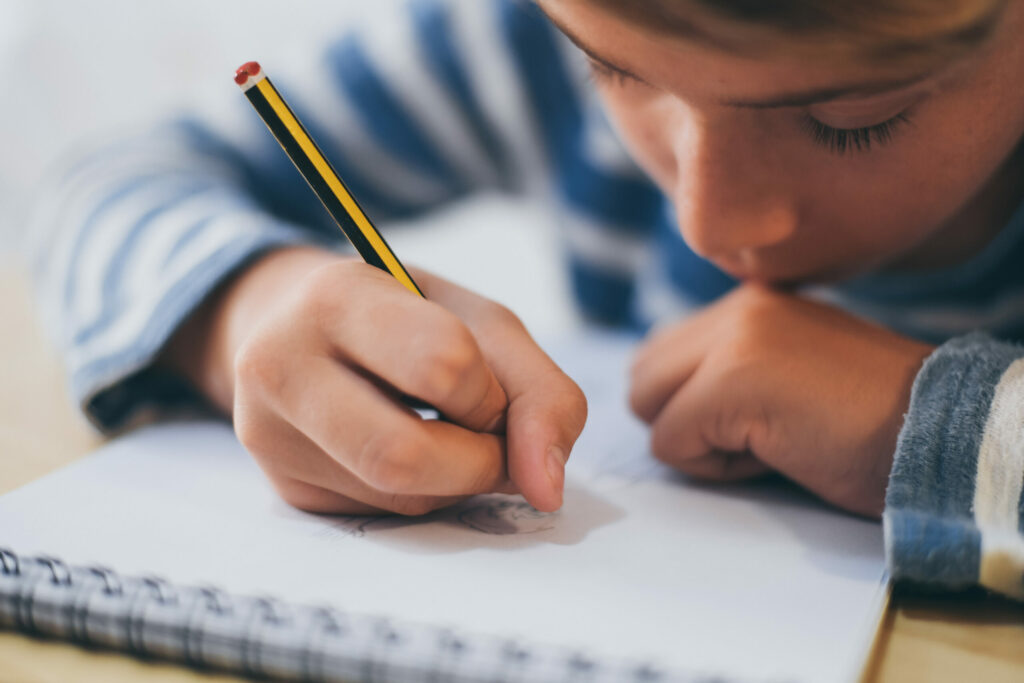 Close up of boy writing on paper