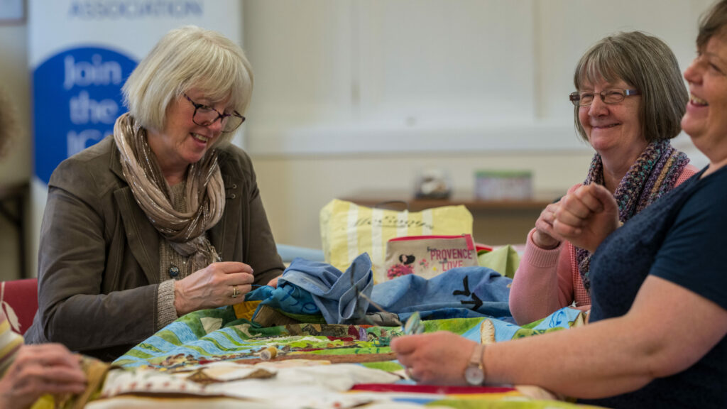 Two women work at arts and crafts at a table